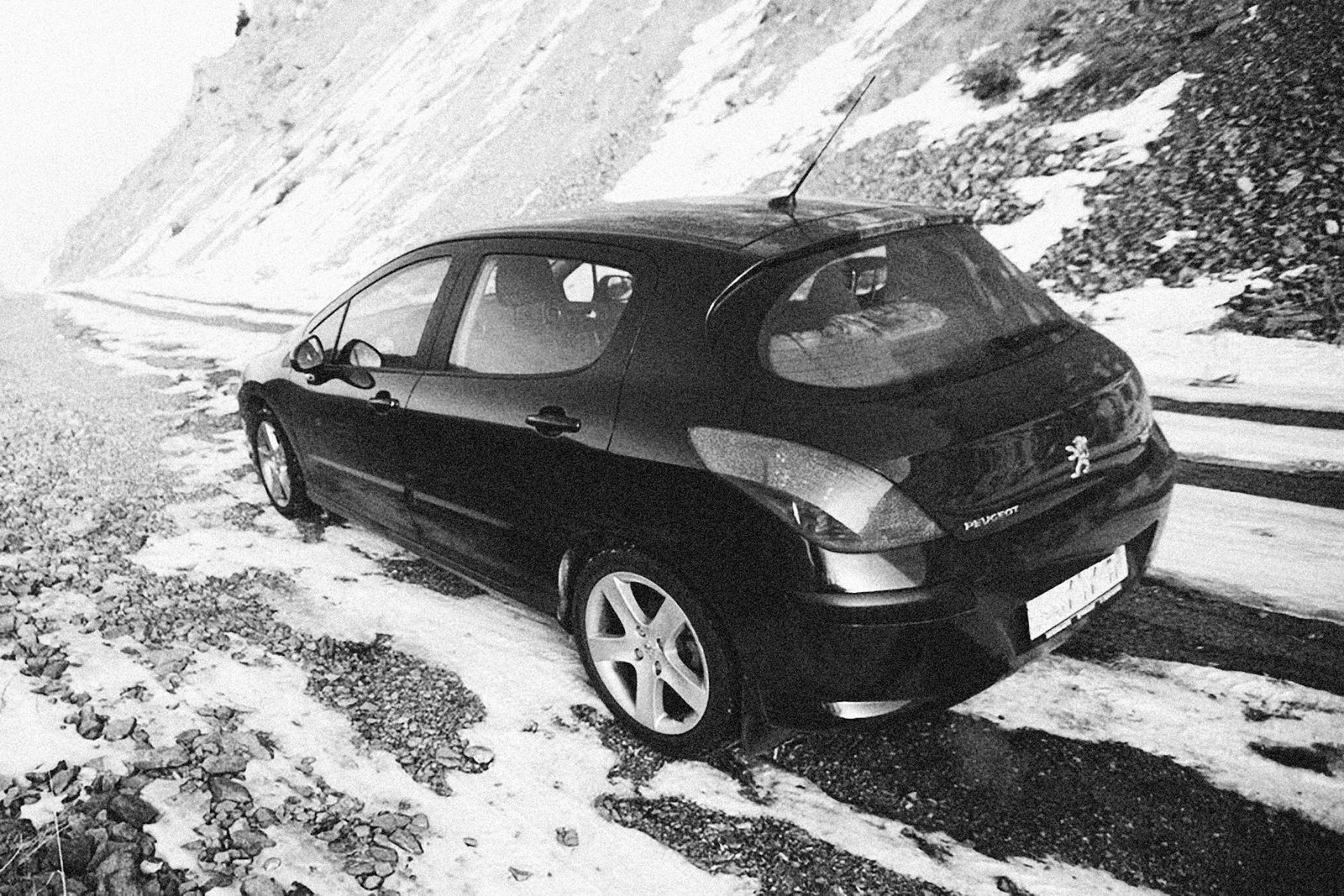 a car parked on the snow covered mountain road